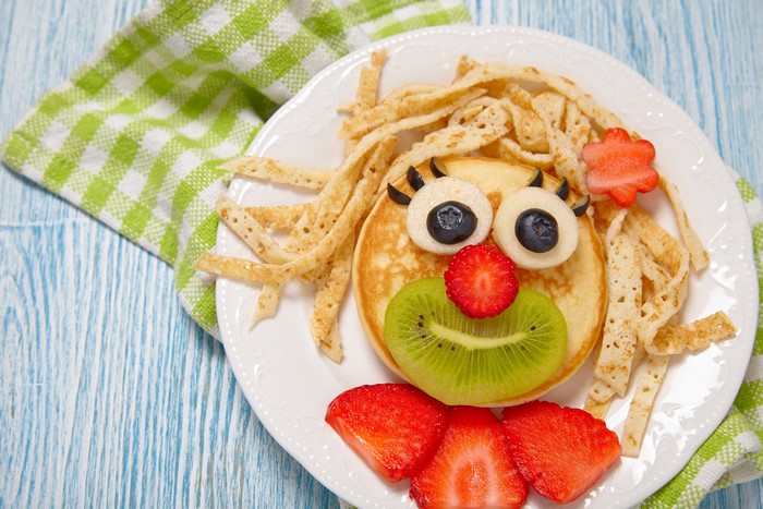Pancake face with fruit on a plate