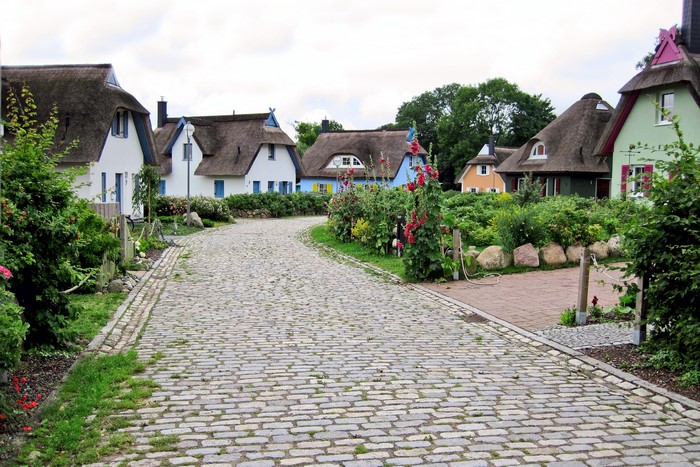 Cobblestone road leading to thatched-roof houses in Germany