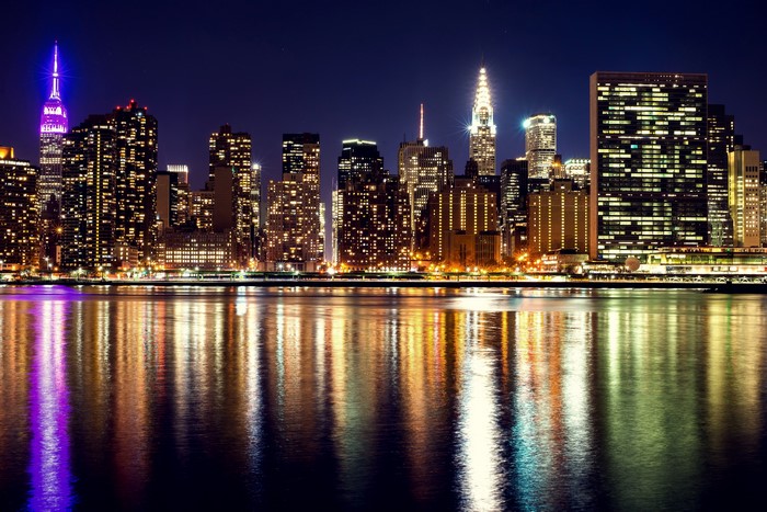 New York City skyline at night with river reflections