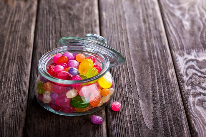 Jar of colorful candies on wood planks