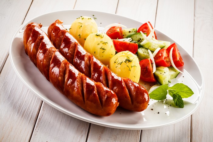 Sausages with potatoes and salad on a plate