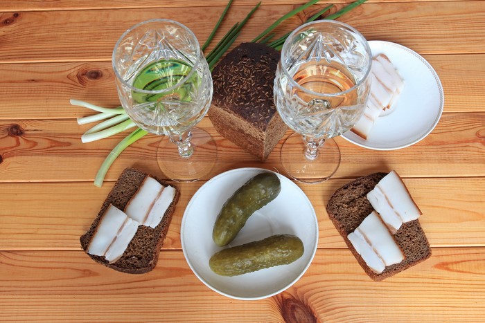 Vodka, Bread, Cucumbers, and Salo on Wood Planks