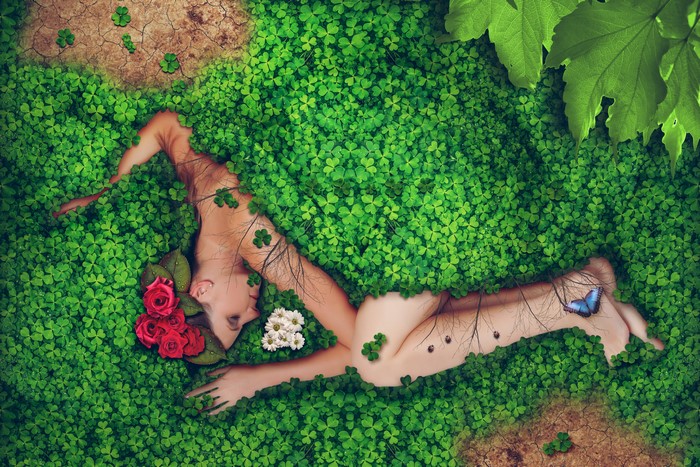 Woman sleeping in clover with flowers and butterfly