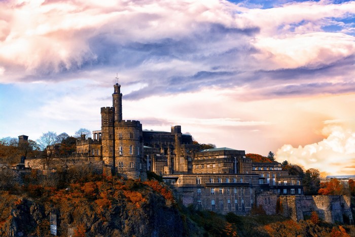 Edinburgh Castle on a hill with dramatic clouds