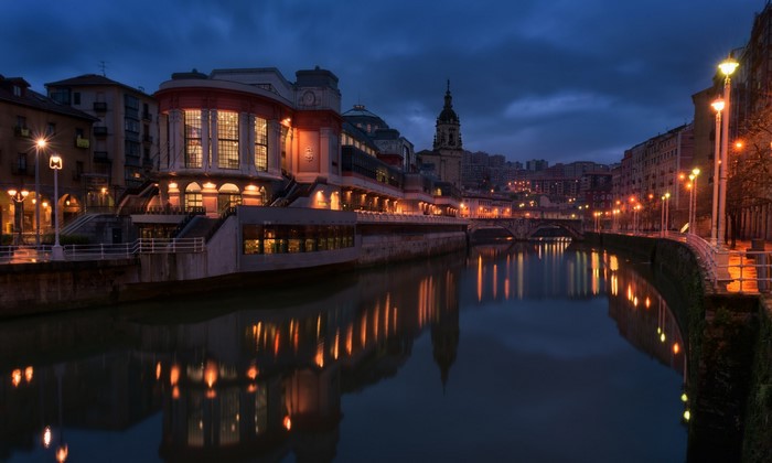 Bilbao riverfront at night with street lights and reflections