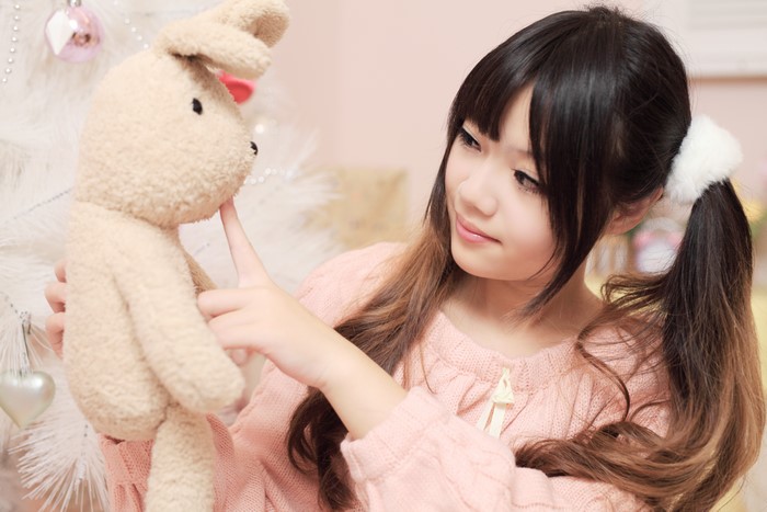 Asian girl with brown hair holding a stuffed rabbit