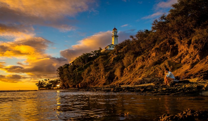 Diamond Head Lighthouse, Hawaii at Sunset with Person on Shore
