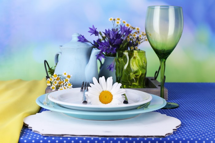 Table setting with kettle, flowers, and wine glass