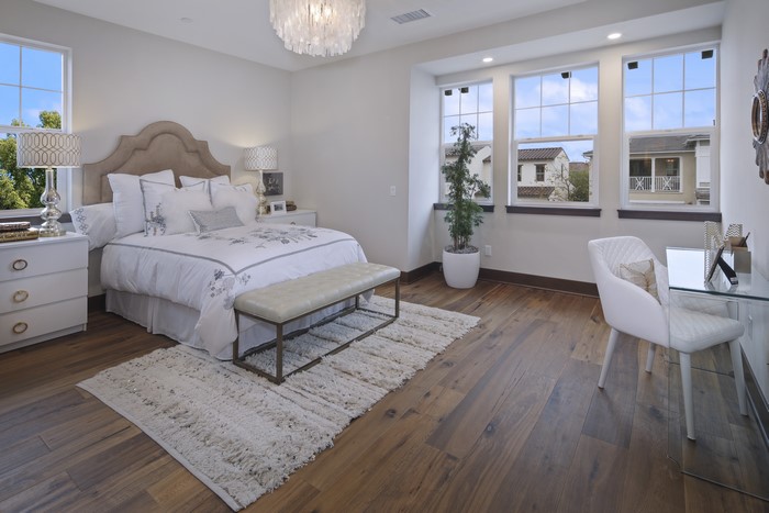 Bedroom with bed, pillows, chairs, and desk
