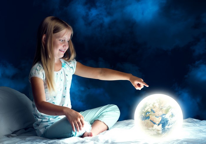 Little girl pointing at glowing Earth