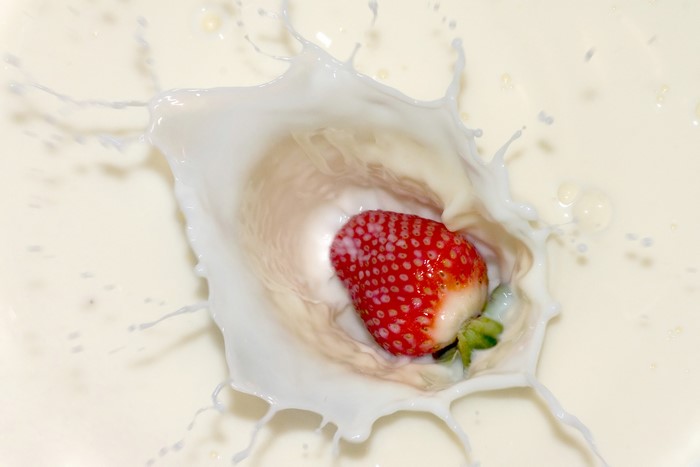 Strawberry splashing into milk