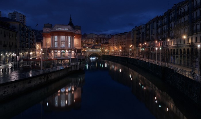 La Ribera Market and Nervion River at Night in Bilbao, Spain