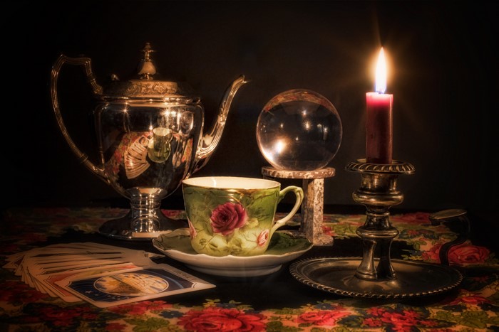 Still life with tea set, crystal ball, and tarot cards