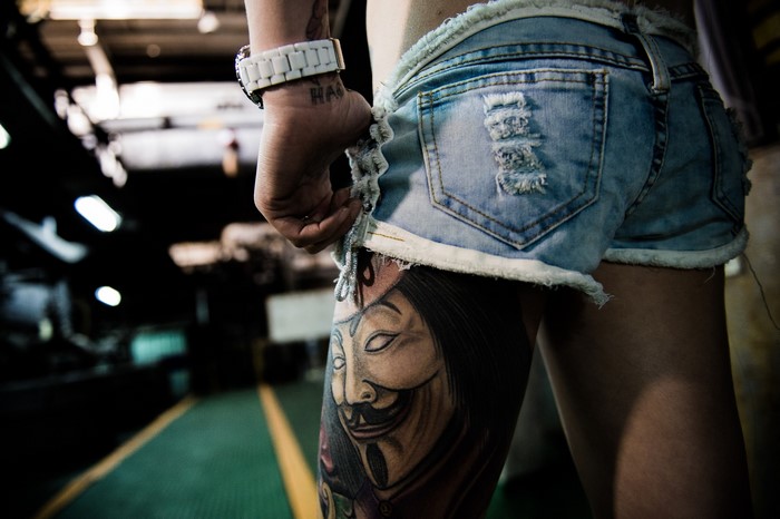 Person with Guy Fawkes mask tattoo on leg