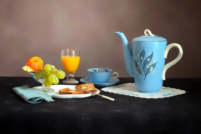 Still-life with breakfast: juice, grapes, tangerine, toast, coffee pot, and cup