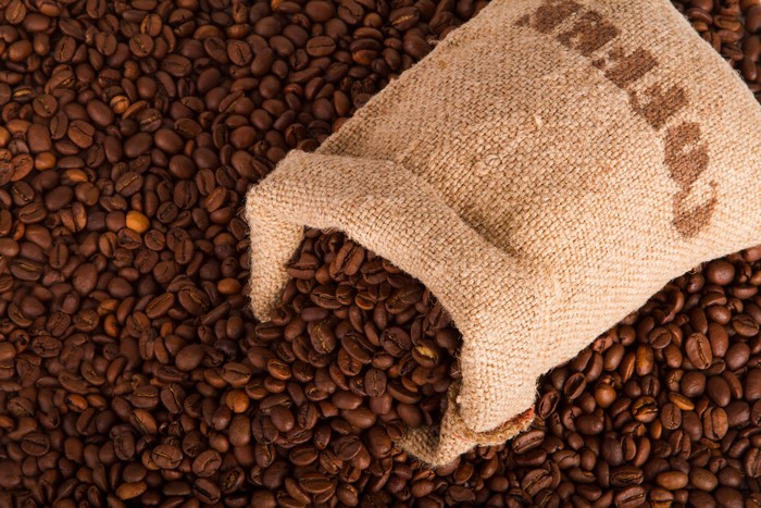 Coffee beans spilling from a burlap sack
