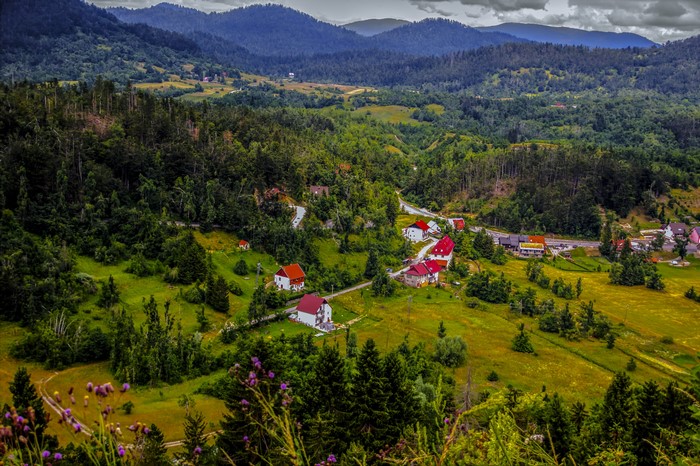 Village nestled in a green valley with forested hills