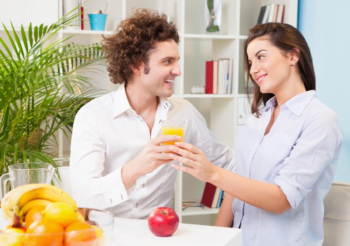 Couple toasting with orange juice