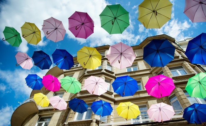 Colorful umbrellas hanging in front of a building