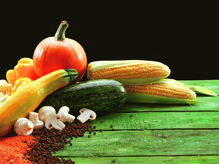 Vegetables including corn, pumpkin, mushrooms on wood planks