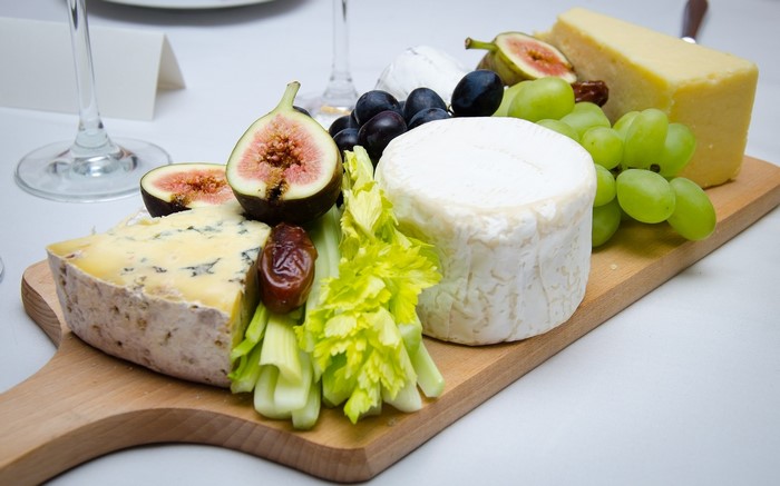 Cheese board with figs, grapes, and celery
