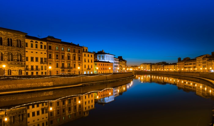 Buildings along a canal in Pisa, Italy at night