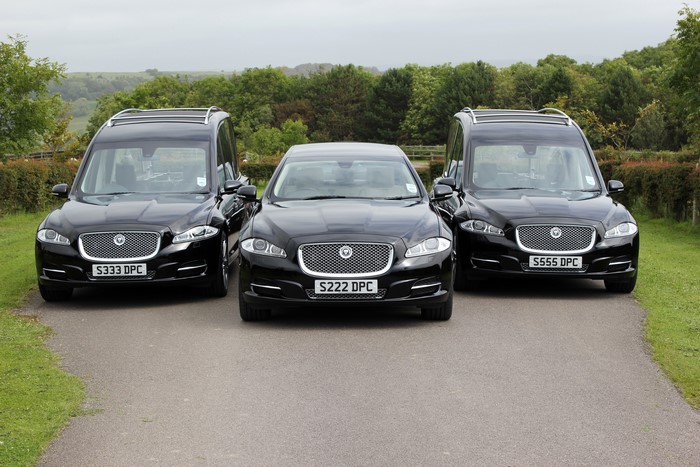 Three black Jaguar XJ hearses and a Jaguar XJ saloon