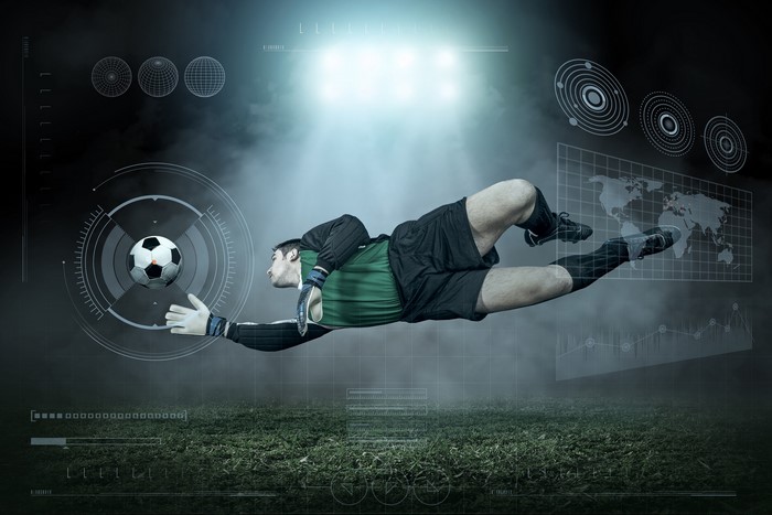 Goalkeeper jumping to save a soccer ball with futuristic graphics