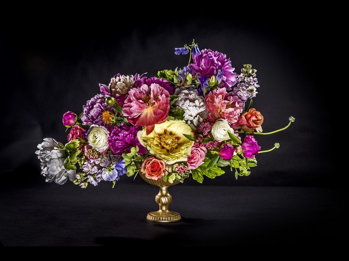 Floral arrangement of peonies and ranunculus in a vase