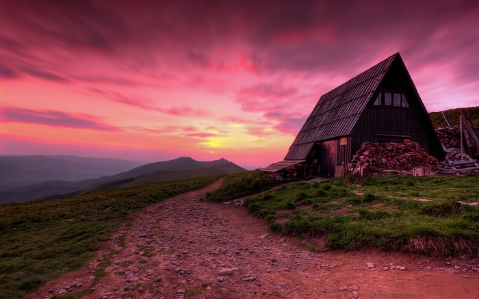 Wooden cabin on a mountain at sunset