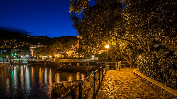 Night view of Opatija, Croatia with illuminated buildings and water