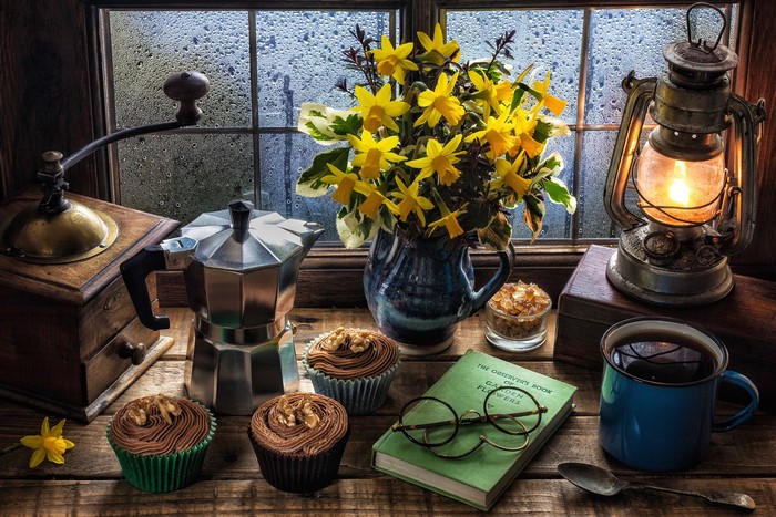 Still-life with daffodils, coffee, and cupcakes