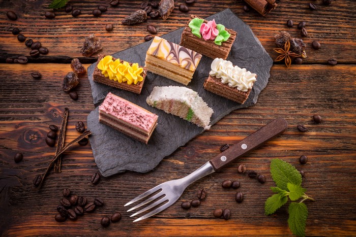 Little cakes with coffee beans on wooden planks