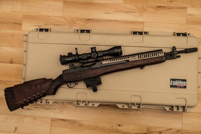 M14 rifle with scope on a case