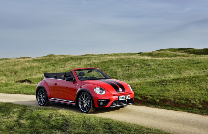 Red Volkswagen Beetle Cabriolet on a dirt road