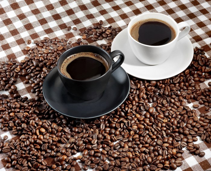 Two cups of coffee with coffee beans