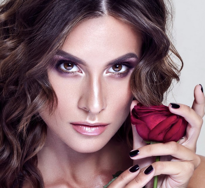 Woman with brown hair holding a red rose