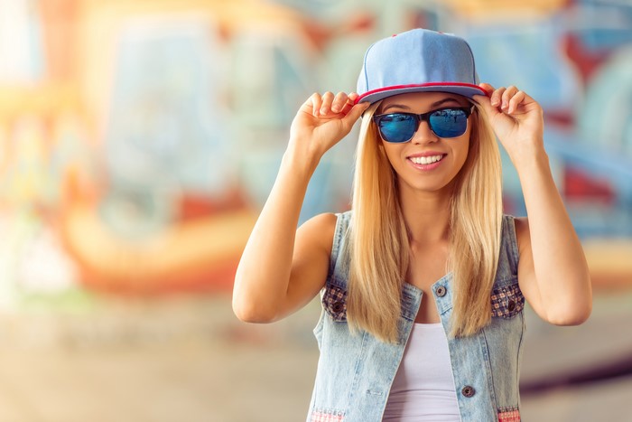 Blonde girl in baseball cap and sunglasses