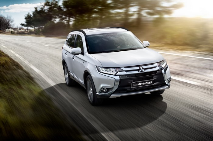 White Mitsubishi Outlander driving on a road