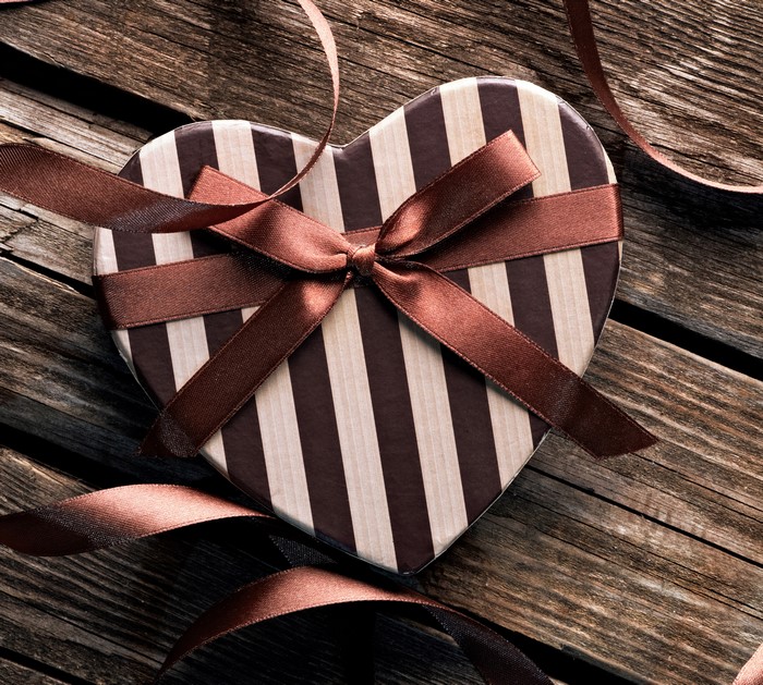 Heart-shaped gift box with brown and white stripes and a brown ribbon