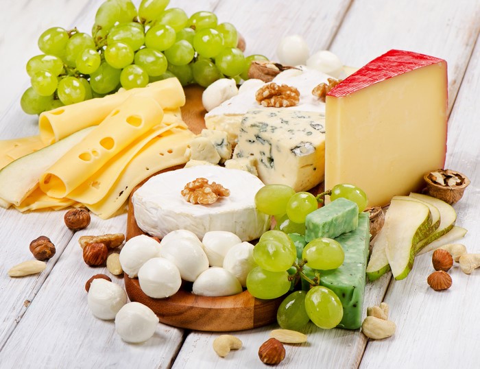 Cheese platter with grapes, nuts, and pears