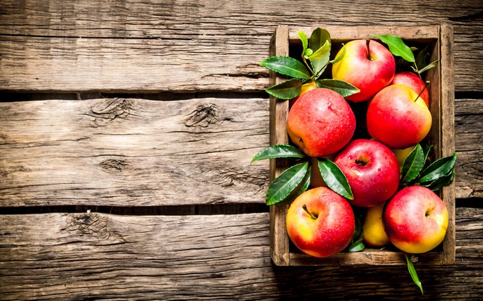 Apples in a wooden crate on wood planks