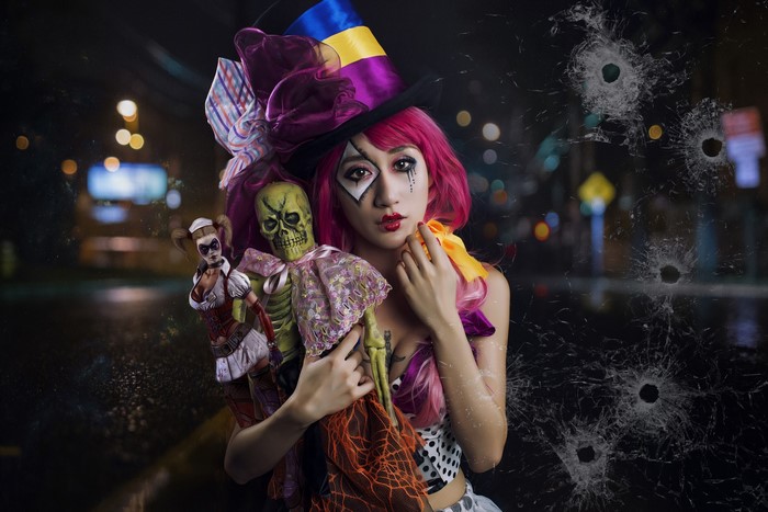 Woman in clown costume holding dolls