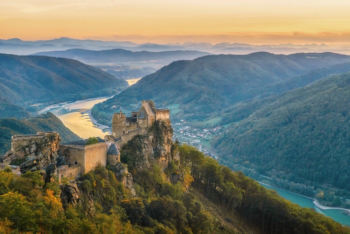 Aggstein Castle overlooking a river valley at sunset
