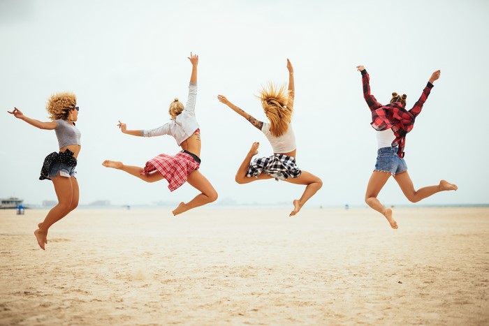 Four women jumping on a beach