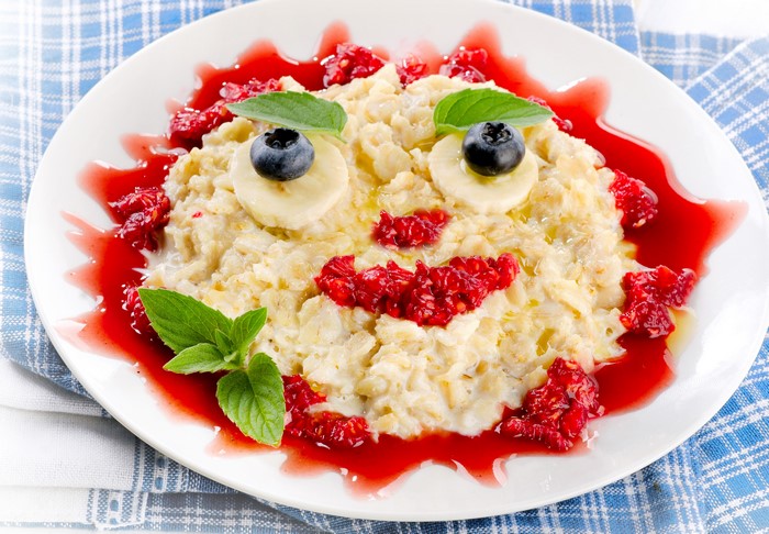 Oatmeal with berries and banana smiley face