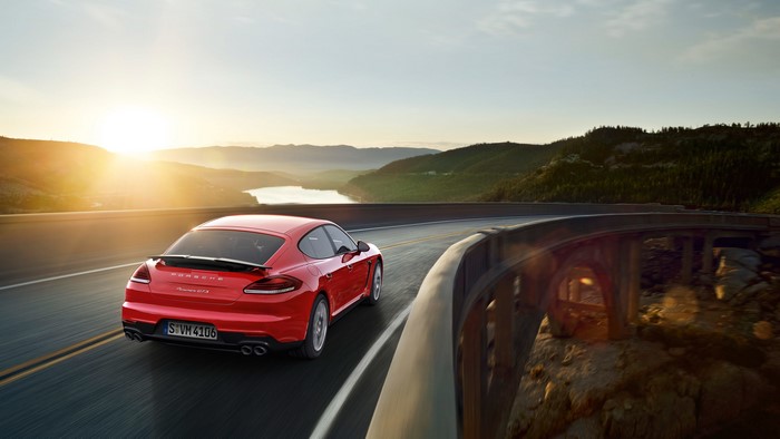 Red Porsche Panamera GTS driving on a scenic road