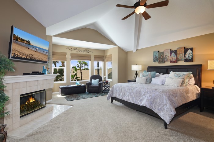 Bedroom with fireplace, armchair, and bed