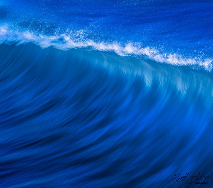 Close-up of a blue ocean wave with white foam
