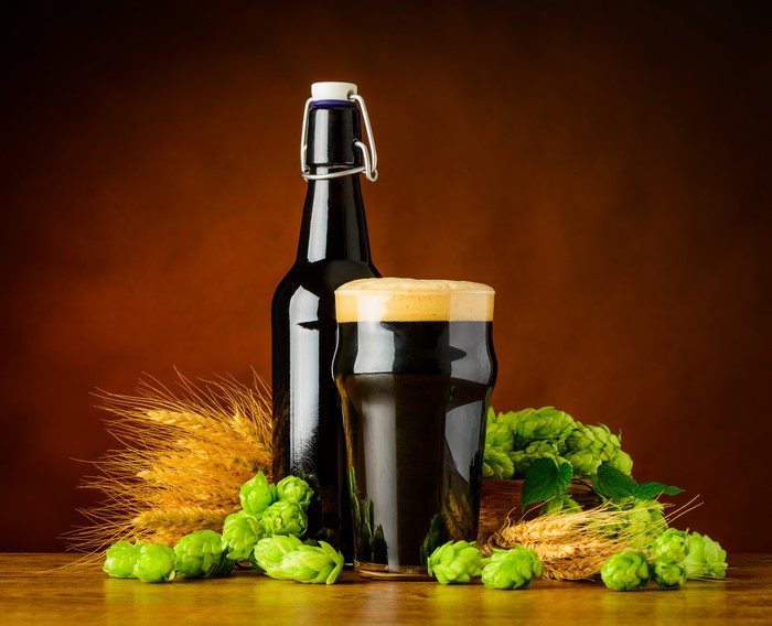 Beer bottle and glass with wheat and hops